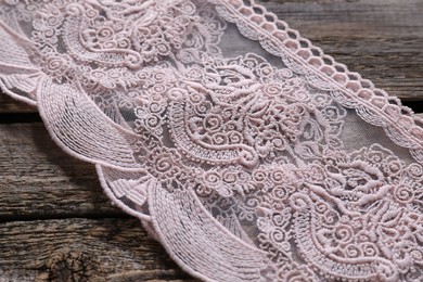 Photo of Pink lace with beautiful pattern on wooden table, closeup