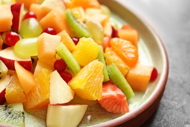 Photo of Plate with fresh cut fruits on table, closeup