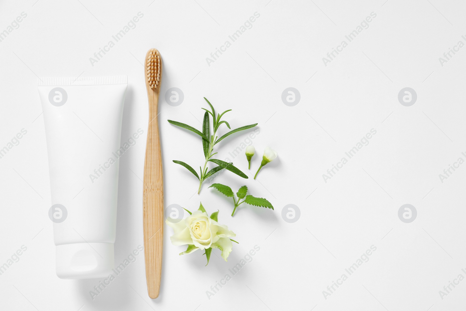 Photo of Flat lay composition with toothbrush, toothpaste, herbs and flowers on white background. Space for text