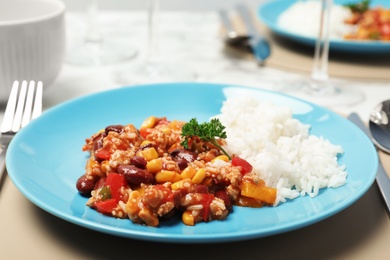 Plate with tasty chili con carne served with rice on table