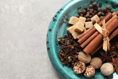 Photo of Different aromatic spices on light textured table, top view. Space for text