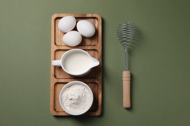Photo of Metal whisk and dough ingredients on khaki background, flat lay