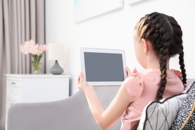 Photo of Cute girl using video chat on tablet at home, space for text