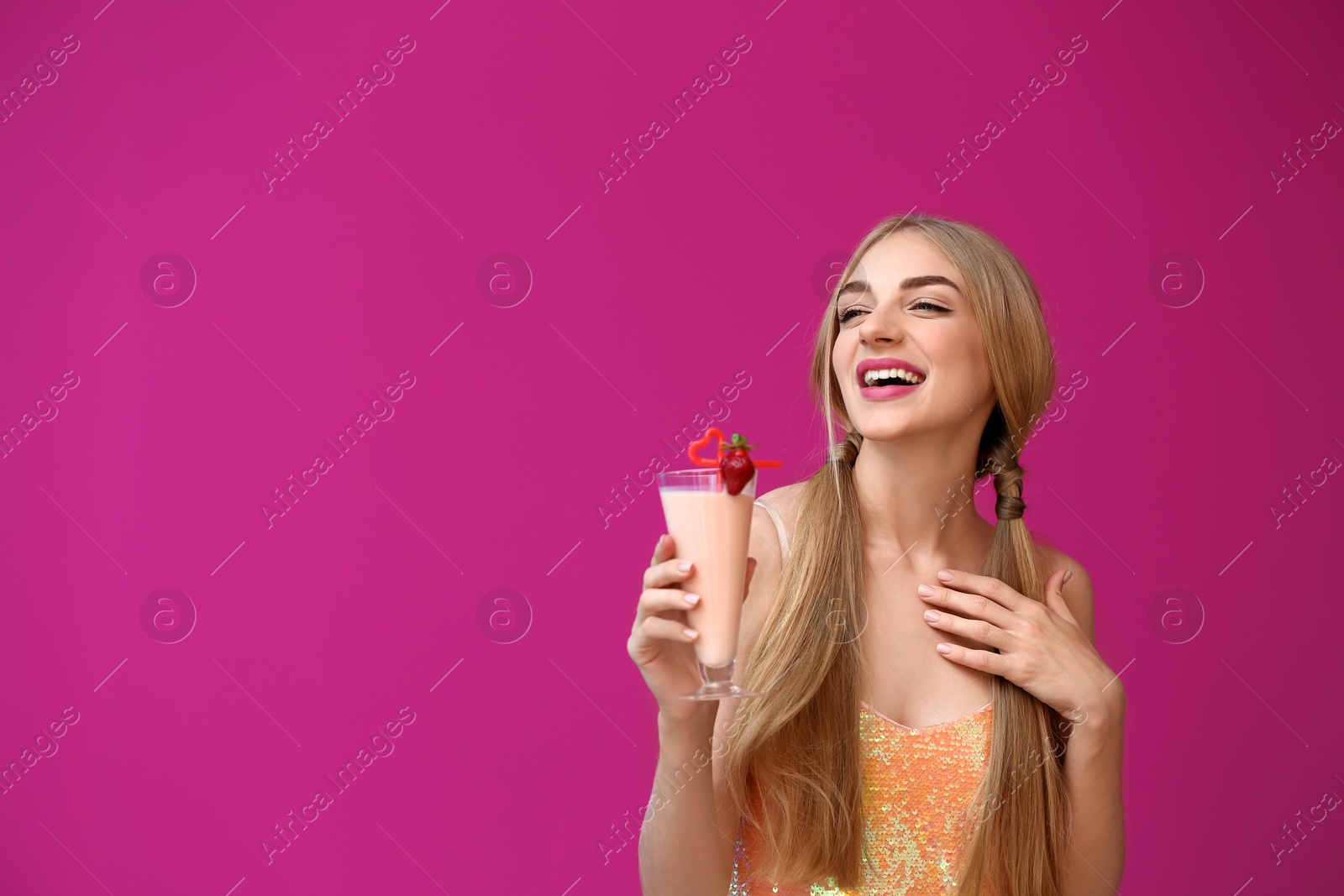 Photo of Young woman with glass of delicious milk shake on color background