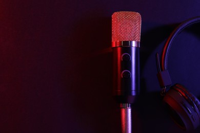 Photo of Microphone and headphones on color background, flat lay with space for text. Sound recording and reinforcement