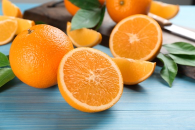Photo of Delicious ripe oranges on light blue wooden table