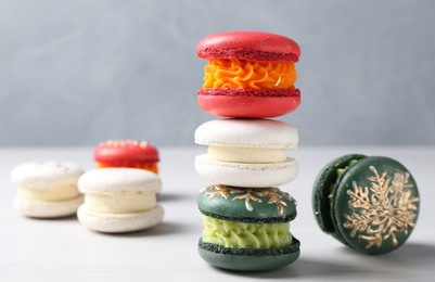 Different decorated Christmas macarons on white table, closeup