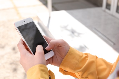 Photo of Young woman using phone outdoors on sunny day