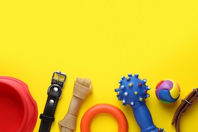 Photo of Flat lay composition with dog collars and different accessories on yellow background, space for text