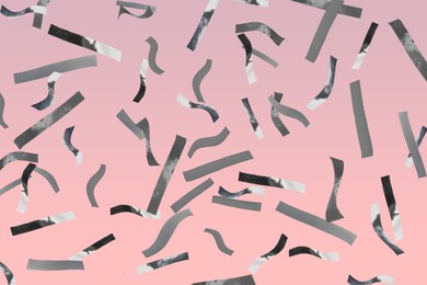 Image of Shiny silver confetti falling on pink background