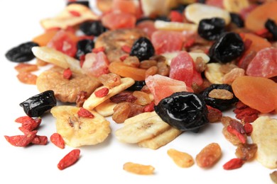 Pile of different tasty dried fruits on white background, closeup