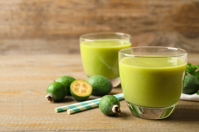 Photo of Fresh feijoa smoothie on wooden table, space for text