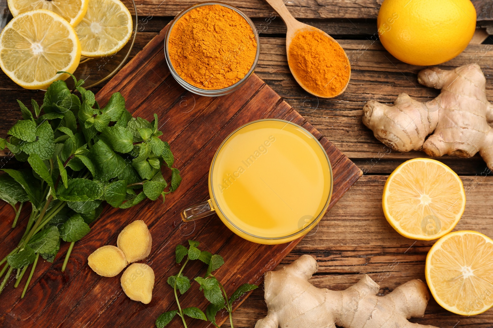 Photo of Flat lay composition with immunity boosting drink and ingredients on wooden table