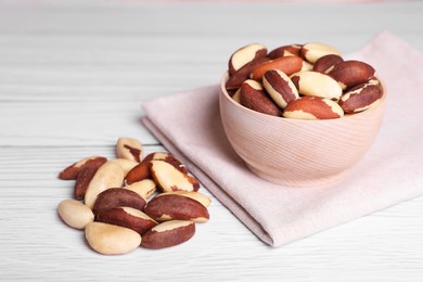 Photo of Many tasty Brazil nuts on white wooden table