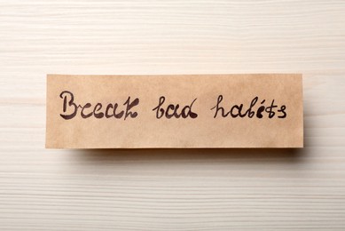 Photo of Paper note with phrase Break Bad Habits on white wooden table, top view