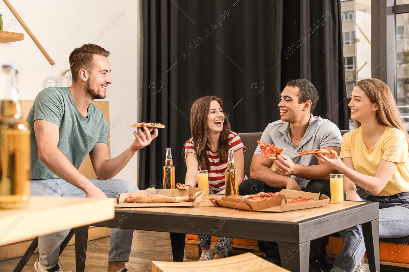 Photo of Group of friends having fun party with delicious pizza in cafe