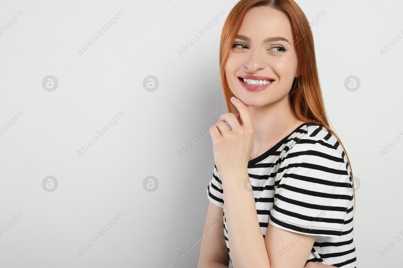 Photo of Portrait of beautiful young woman on light gray background, space for text