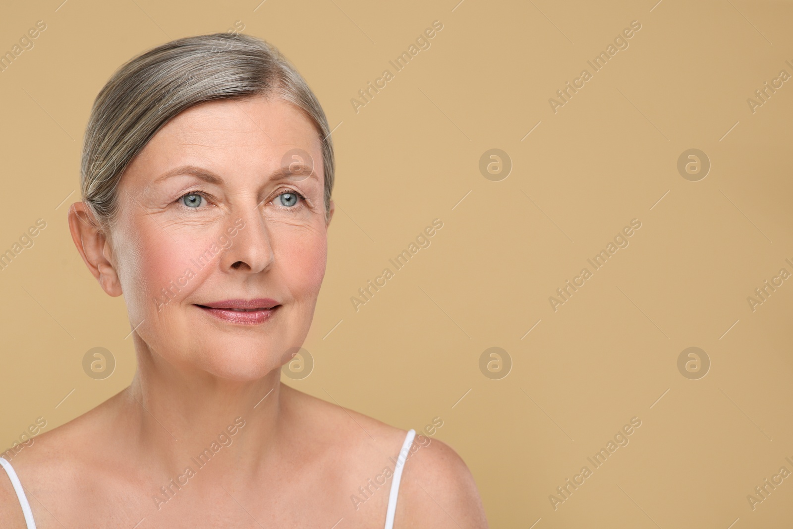 Photo of Portrait of senior woman with aging skin on beige background, space for text. Rejuvenation treatment