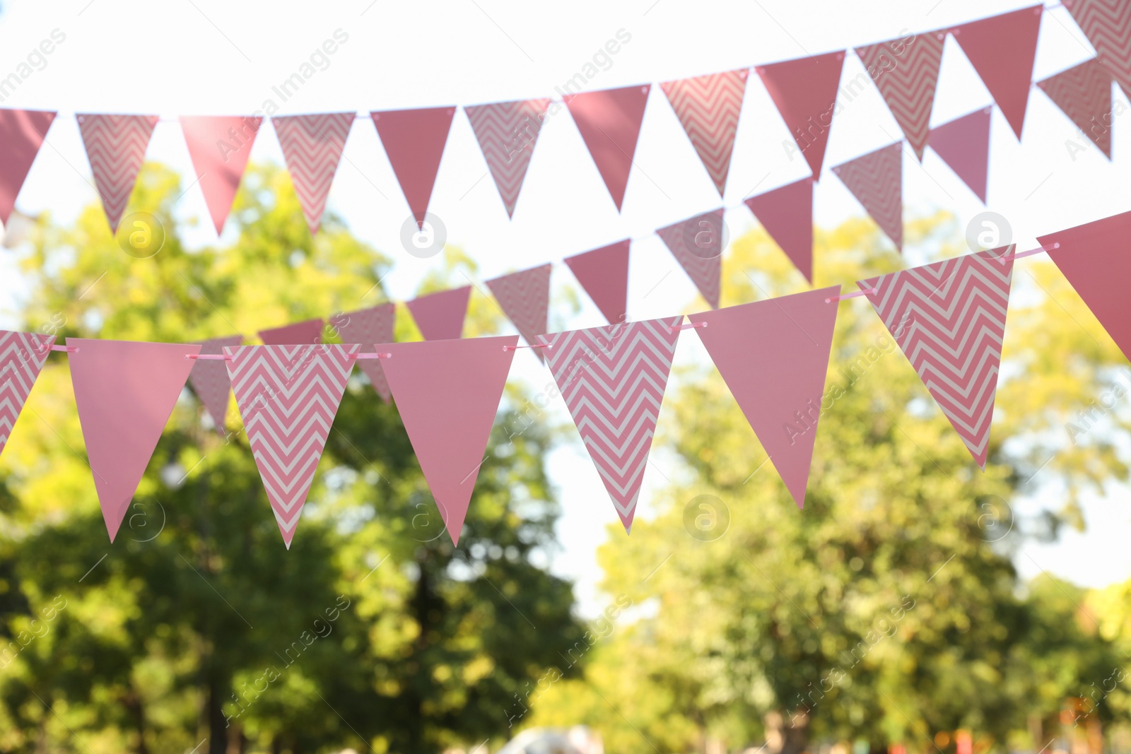 Photo of Pink bunting flags in park. Party decor