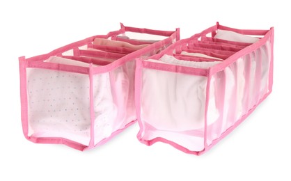 Photo of Transparent organizers with folded clothes on white background