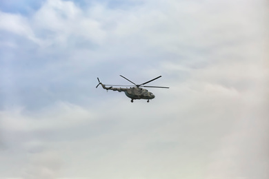 Distant view of military helicopter flying in sky