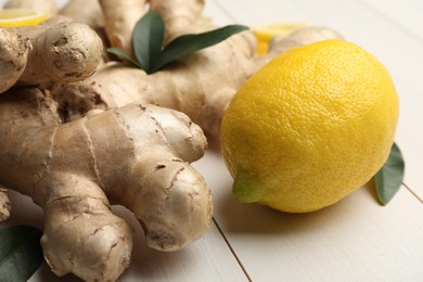 Photo of Fresh lemon and ginger on white wooden table, closeup