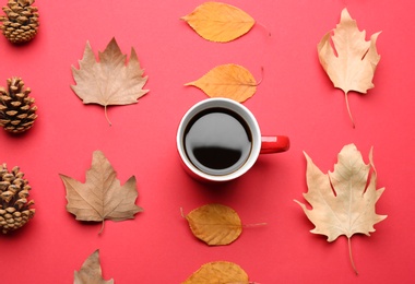 Photo of Flat lay composition with cup of hot drink on red background. Cozy autumn atmosphere