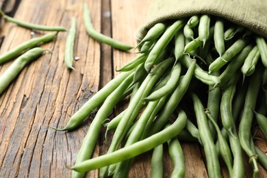 Photo of Fresh green beans in bag on wooden table, closeup