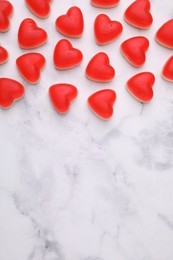 Photo of Delicious heart shaped jelly candies on white marble table, flat lay. Space for text