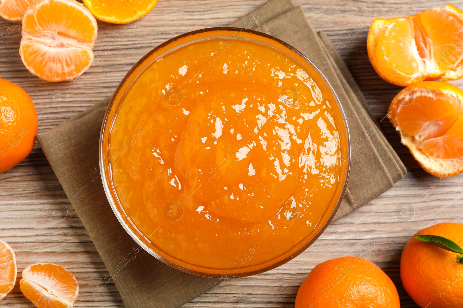 Photo of Flat lay composition with delicious tangerine jam on wooden table