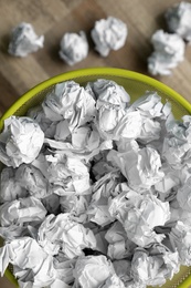 Photo of Metal bin with crumpled paper on floor, top view