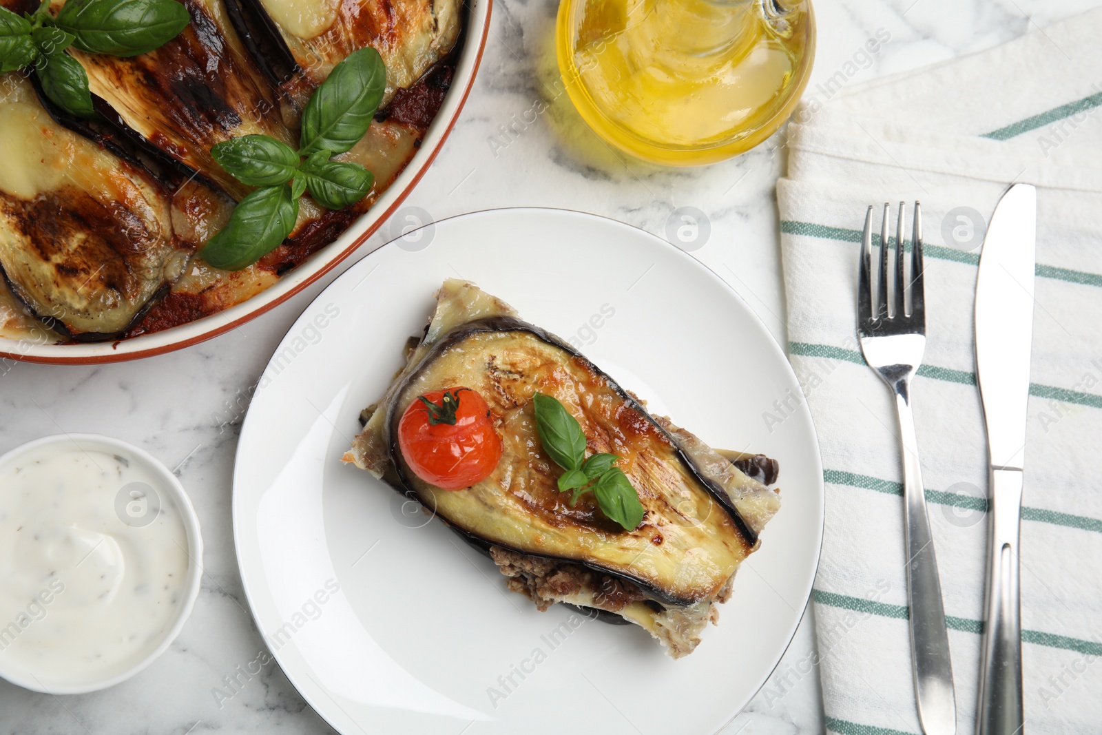 Photo of Delicious eggplant lasagna served on white marble table, flat lay