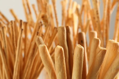Photo of Delicious grissini sticks on light background, closeup