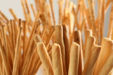 Delicious grissini sticks on light background, closeup