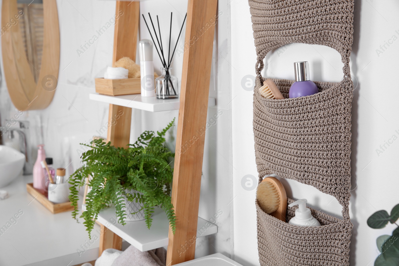 Photo of Knitted organizer hanging on wall in bathroom