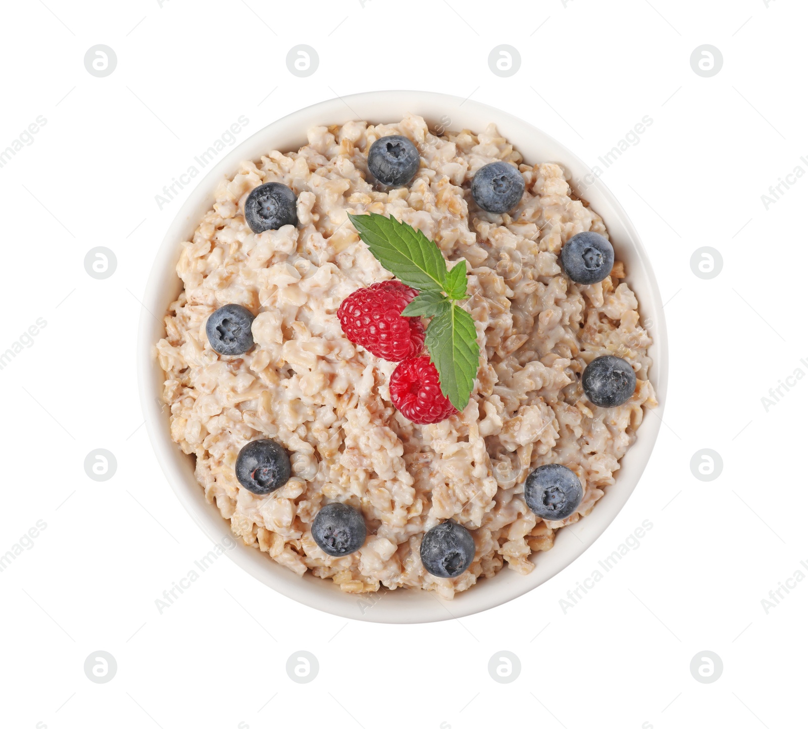 Photo of Tasty boiled oatmeal with berries in bowl isolated on white, top view