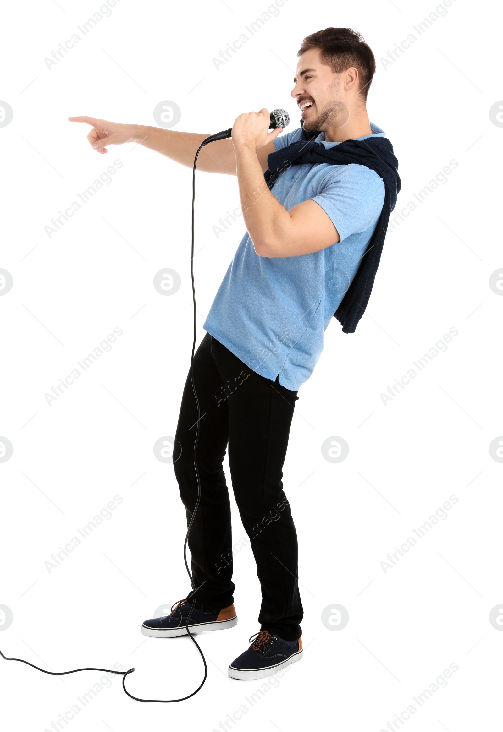 Photo of Young handsome man in casual clothes singing with microphone on white background