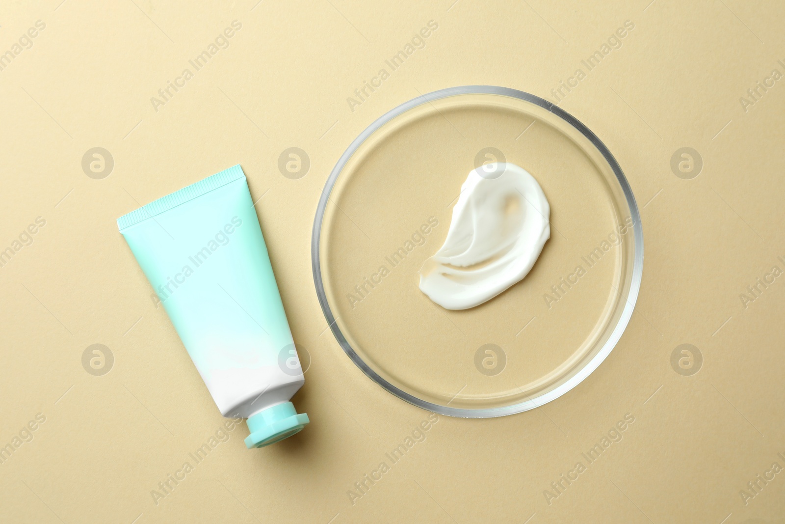 Photo of Petri dish and cosmetic product on beige background, flat lay
