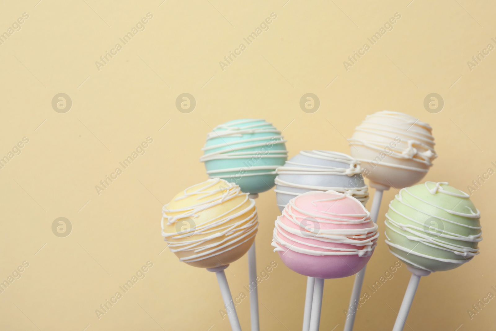 Photo of Sweet colorful cake pops on yellow background