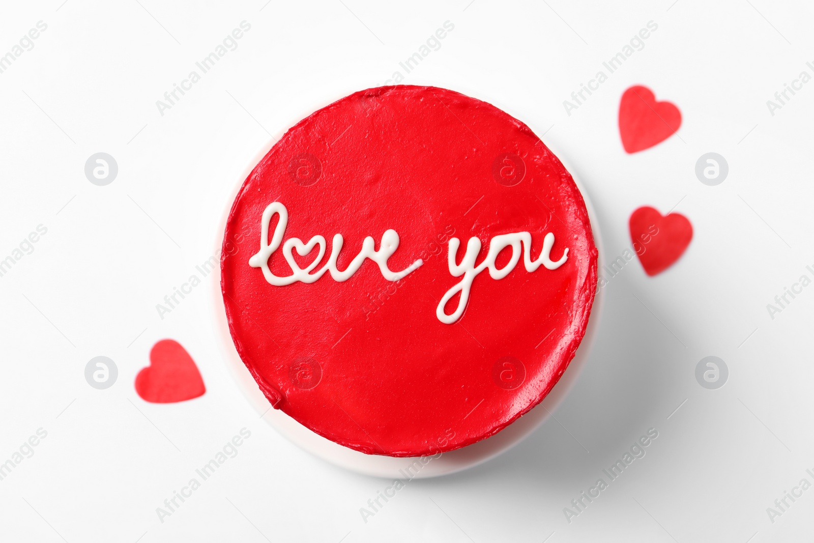 Photo of Bento cake with text Love You and paper hearts on white background, top view. St. Valentine's day surprise