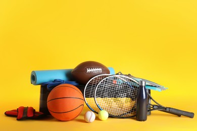 Set of different sports equipment on yellow background