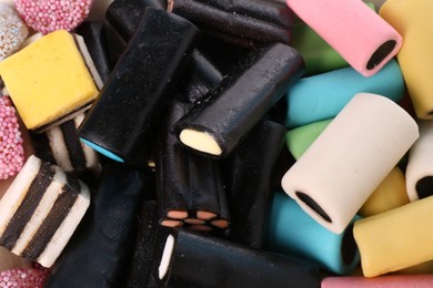 Many tasty liquorice candies as background, closeup