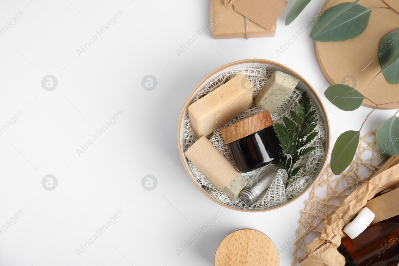 Photo of Cardboard box with eco friendly personal care products on light background, flat lay. Space for text