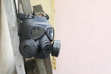 Photo of One gas mask hanging on building outdoors. Space for text