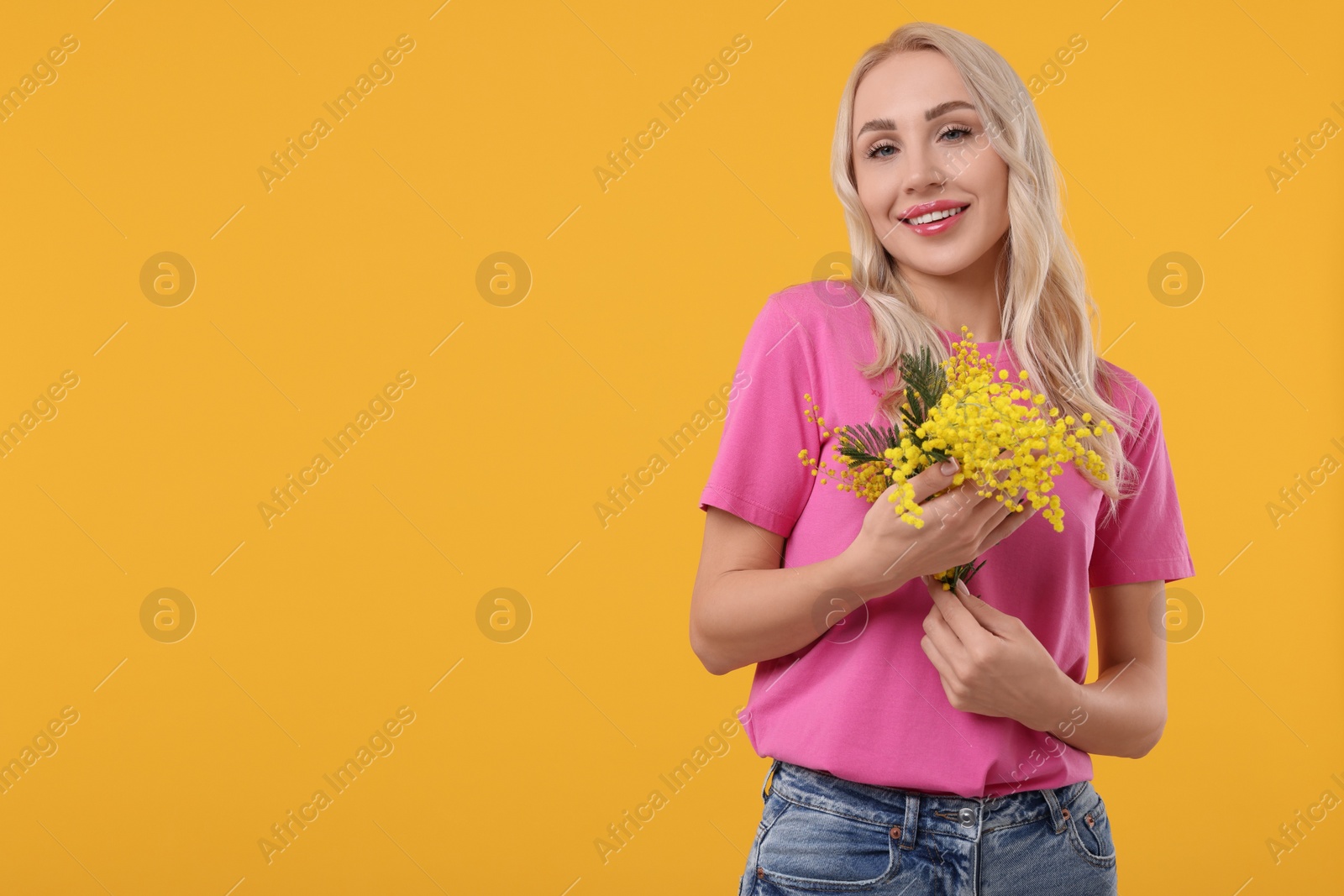 Photo of Happy young woman with beautiful bouquet on orange background. Space for text