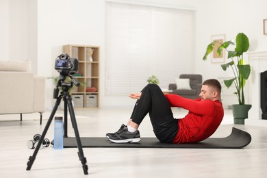 Photo of Trainer recording workout on camera at home