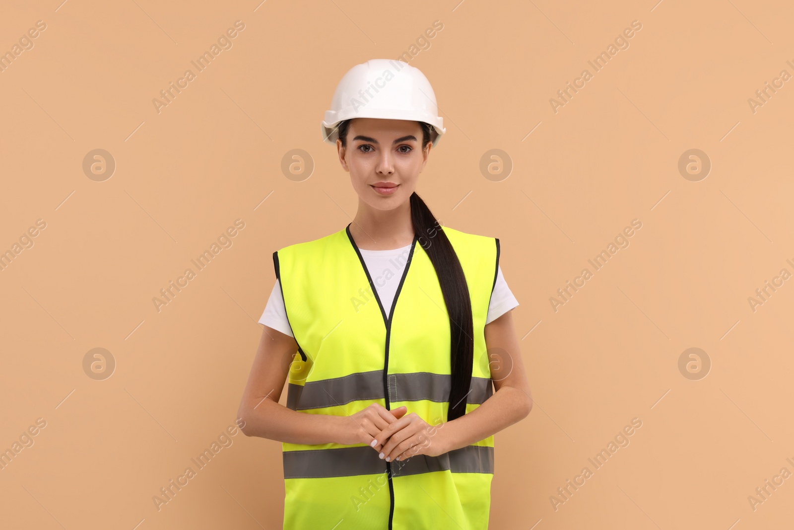 Photo of Engineer in hard hat on beige background