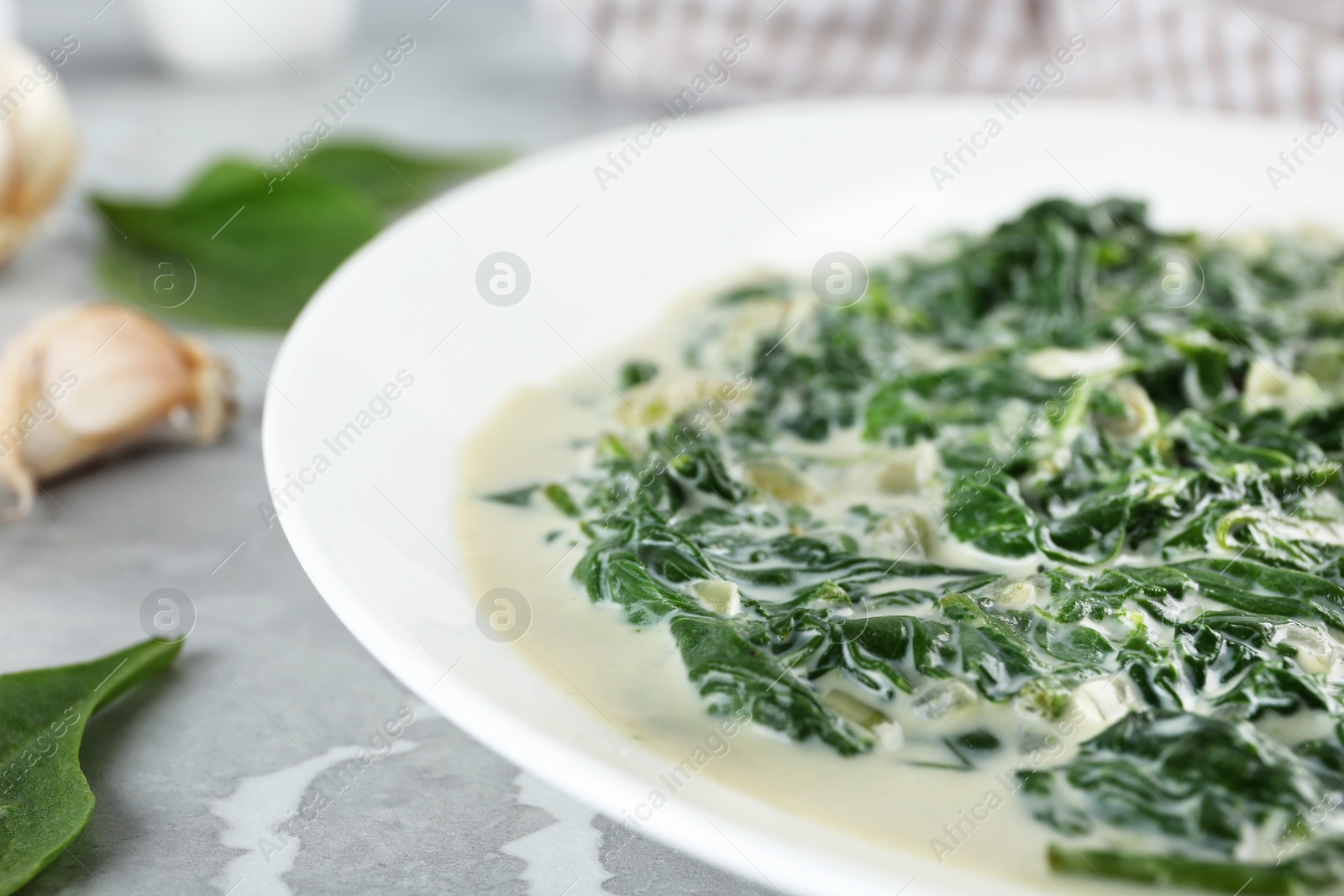 Photo of Tasty spinach dip on grey marble table, closeup