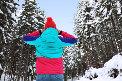 Photo of Woman in pine forest, back view. Winter vacation