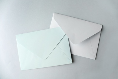 White paper envelopes on light grey background, top view